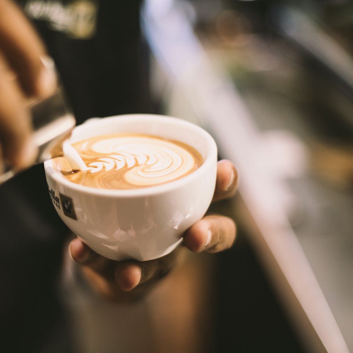 A latte in a ceramic cup on a saucer