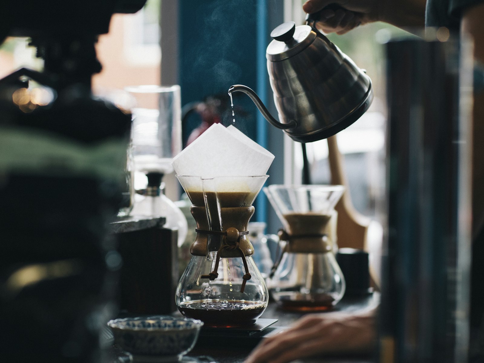 Water being poured over coffee in a glass pour over brewer