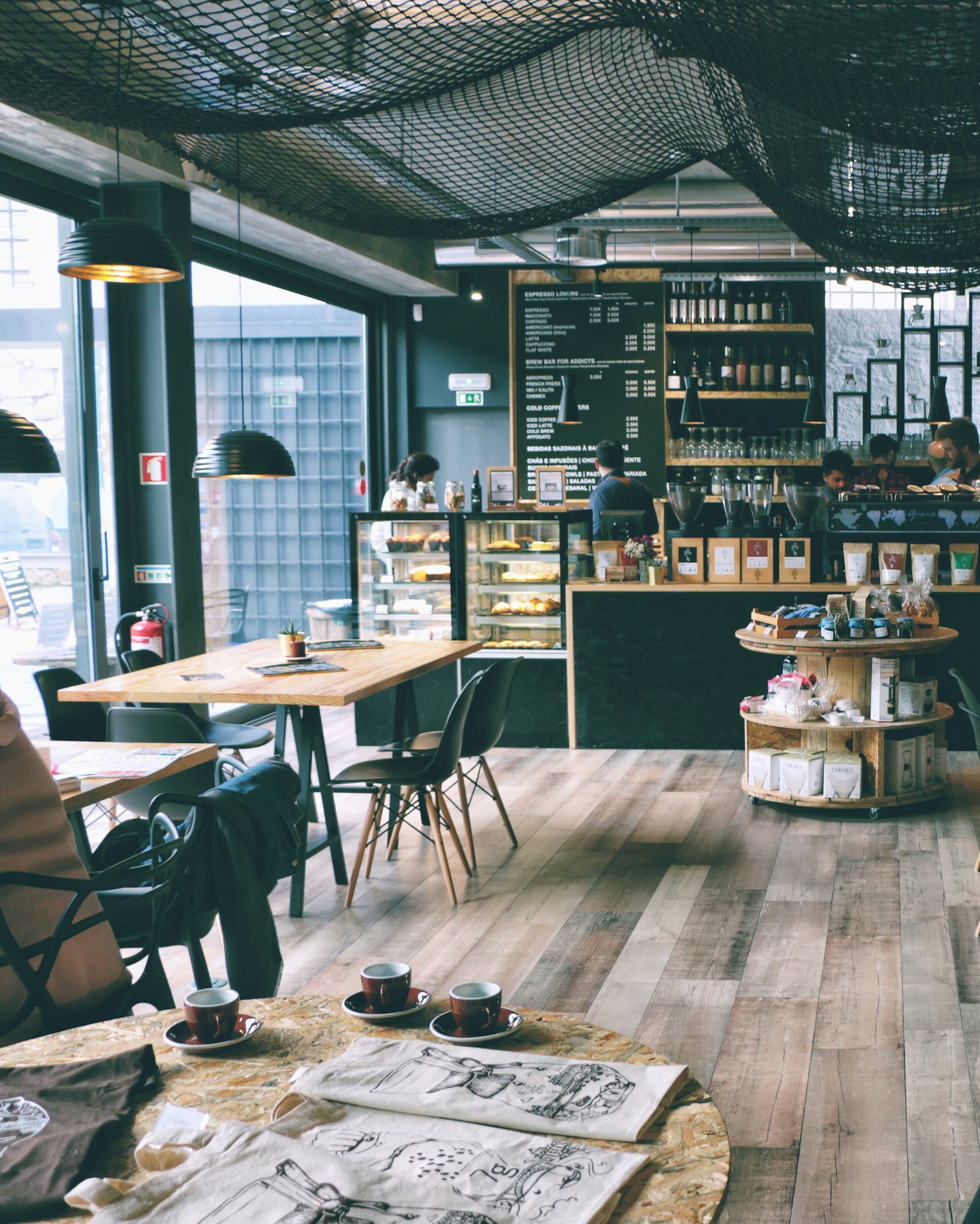 Inside a bright coffee shop with wooden tables and a long counter