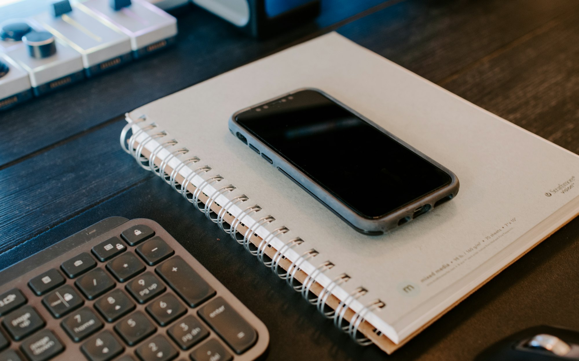 The Fieldnote app on a phone next to a paper notebook