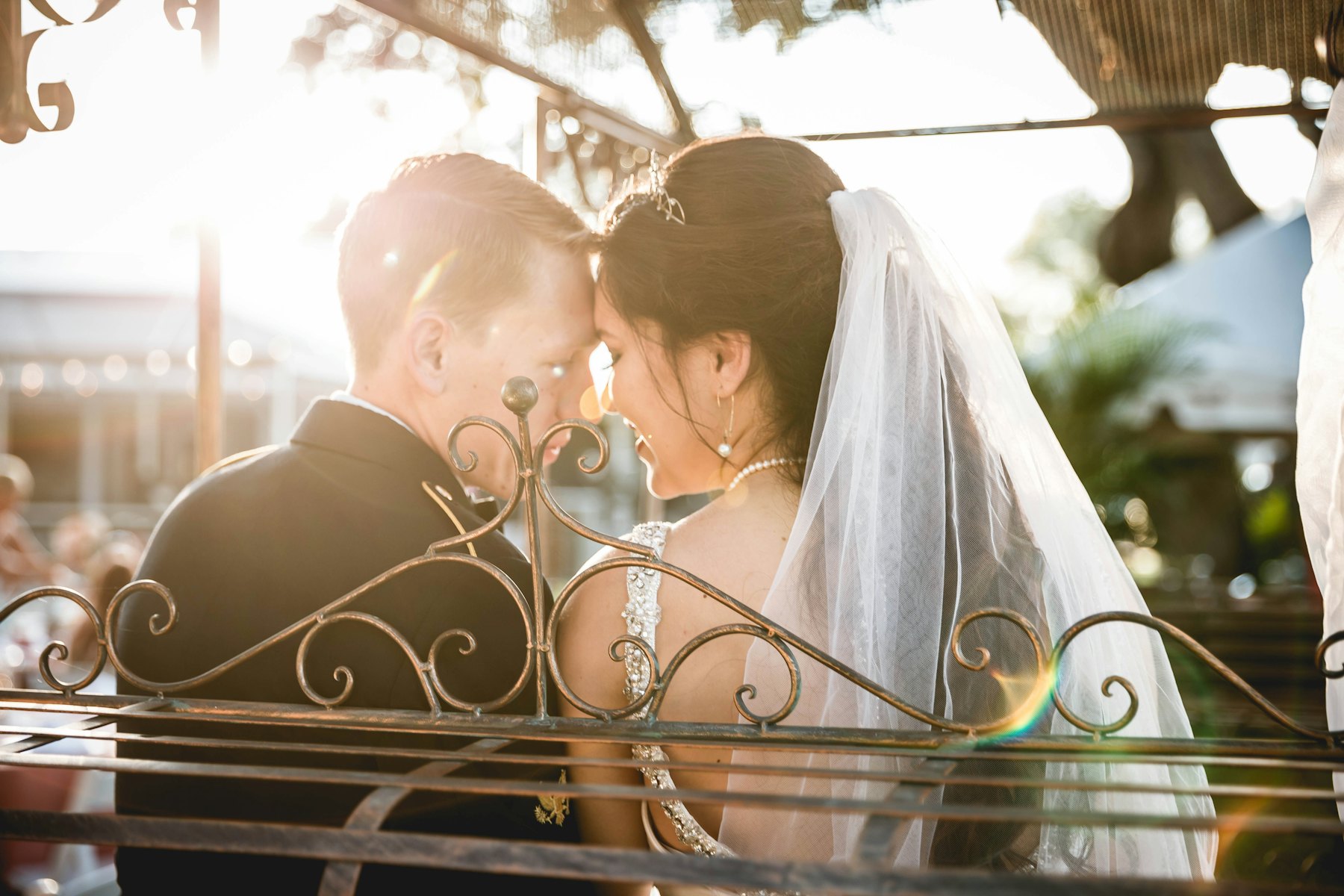 A couple touching foreheads at a sunlit reception
