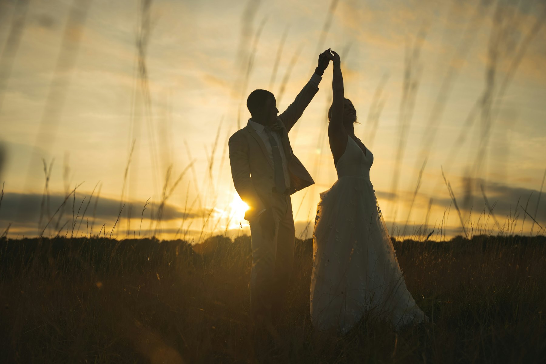The couple in silhouette against a golden evening sky