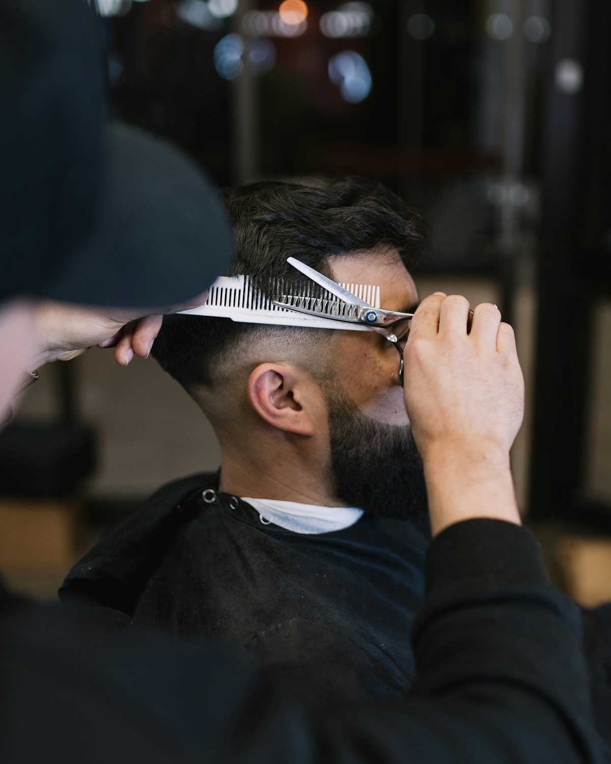 A scissor cut being finished with a comb