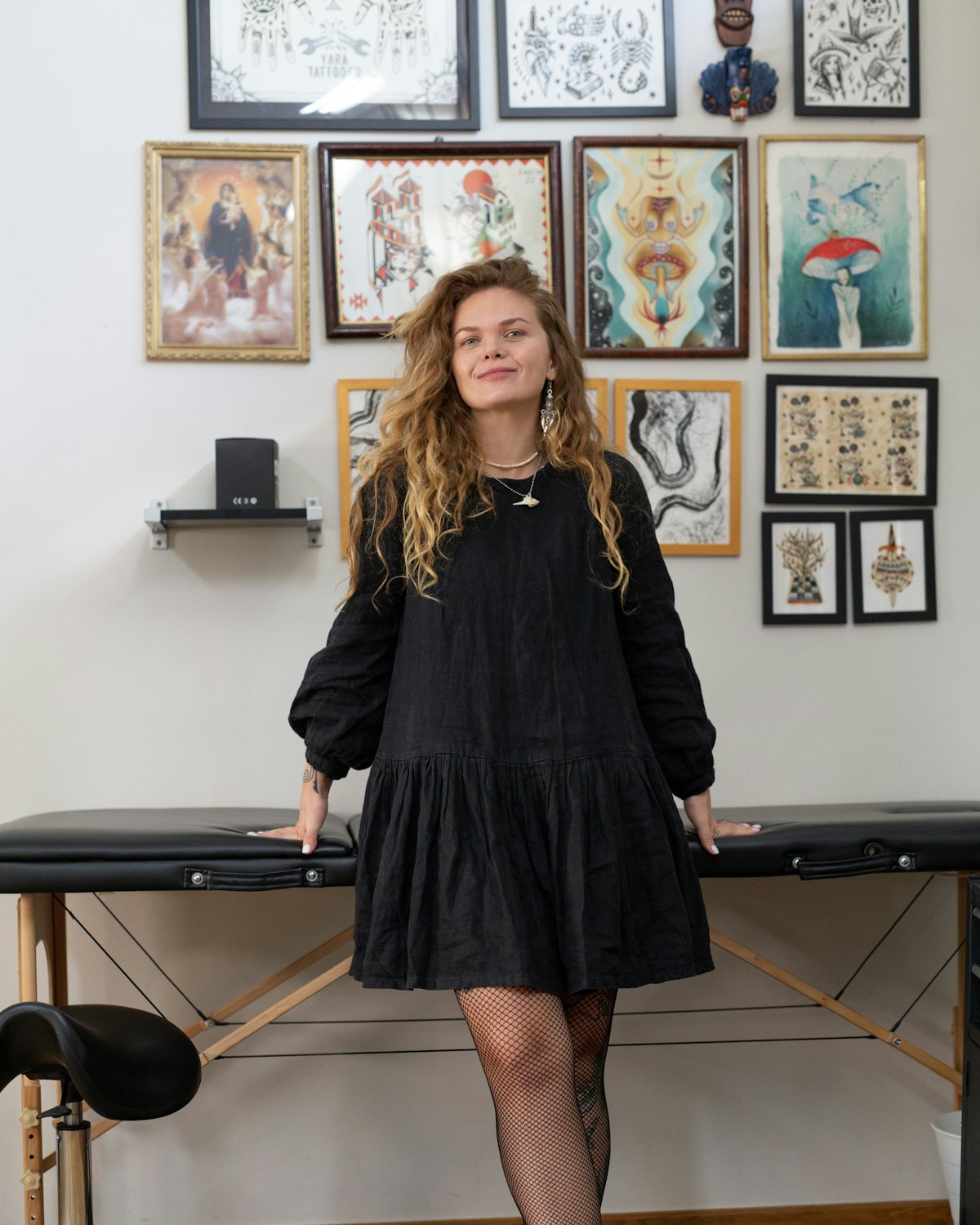An artist standing in front of a wall of framed flash